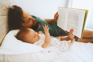 father reading a book to his baby